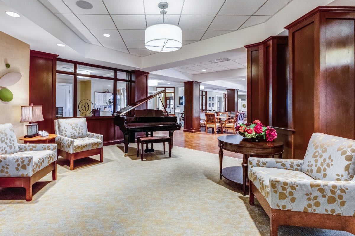 A spacious and elegant lobby featuring a grand piano, comfortable seating, and tasteful decor.