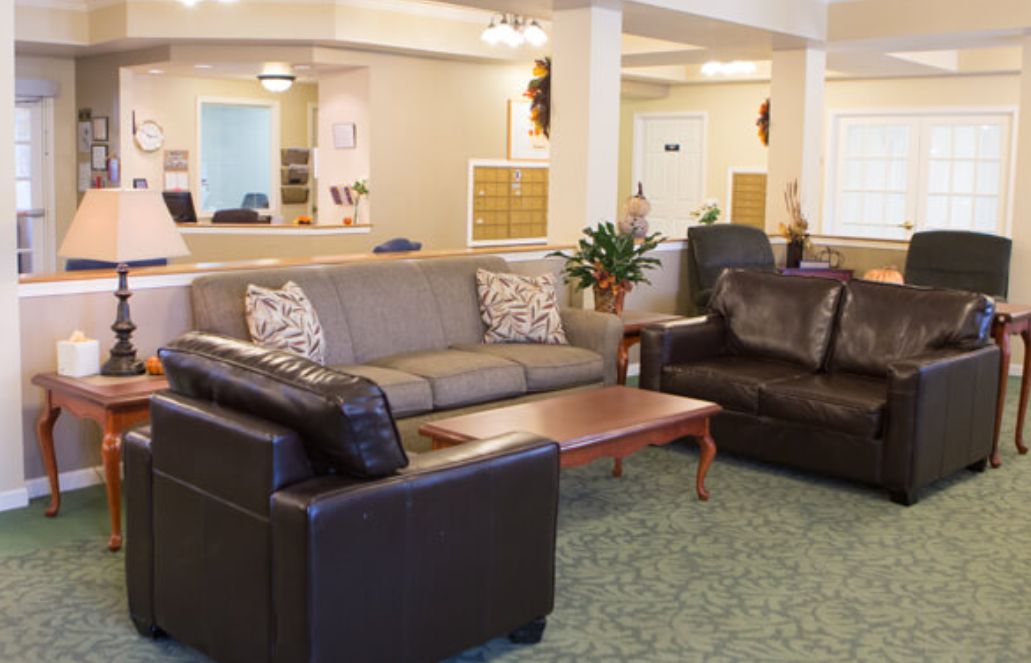 A cozy living room area featuring comfortable leather sofas and a wooden coffee table.