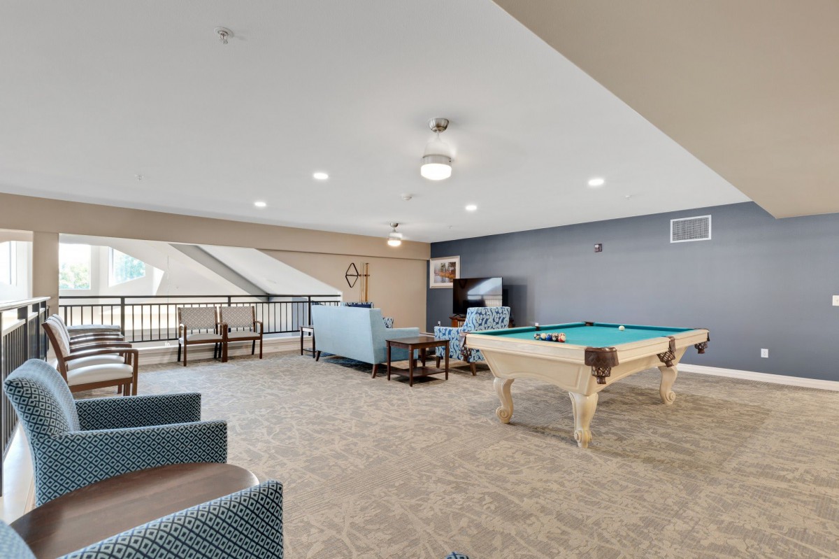 A spacious lounge area with a pool table and comfortable seating arrangements.