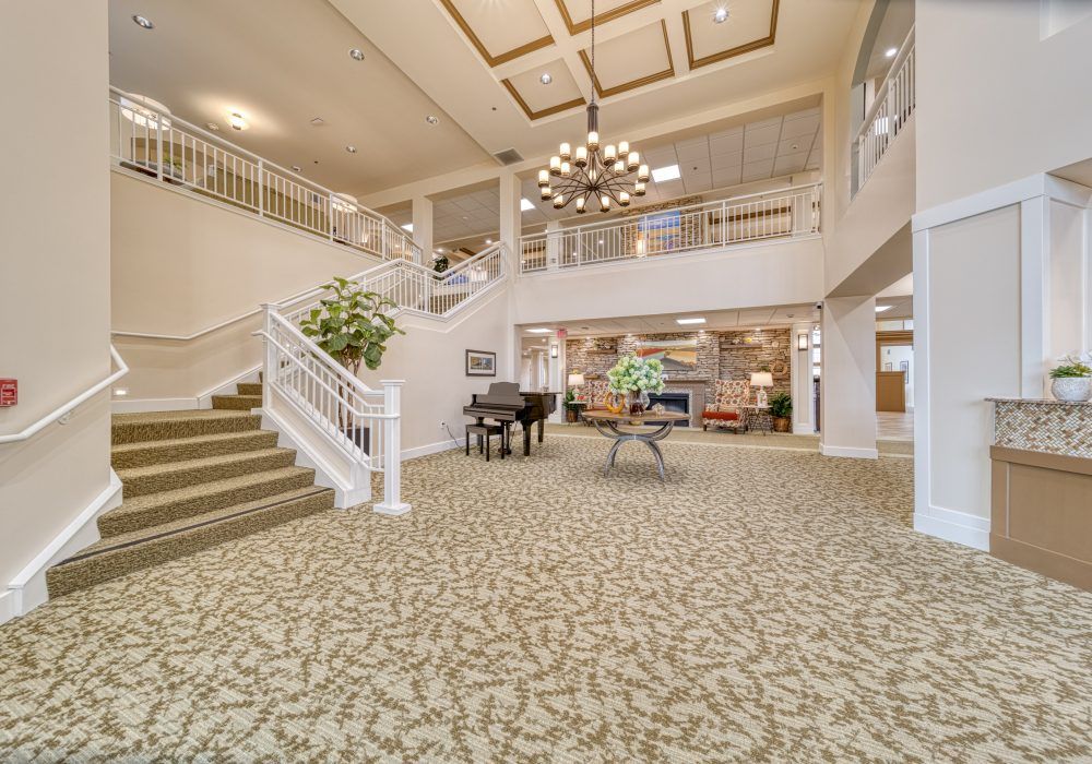 A spacious and elegantly decorated lobby with a grand piano and chandelier.