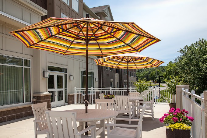 Outdoor patio area with tables, chairs, and striped umbrellas.