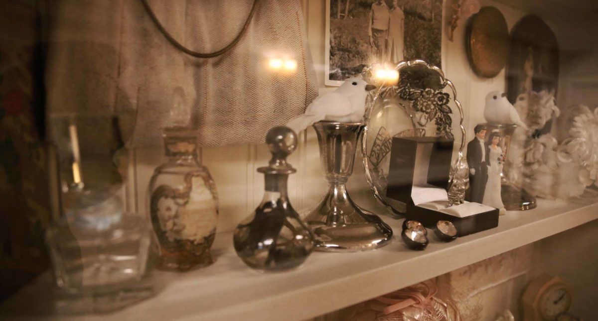 A collection of vintage decor items, including ornate perfume bottles and a decorative mirror, displayed on a shelf.