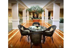 A spacious lobby area with wicker furniture and decorative plants.