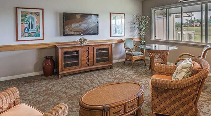 A cozy living room with wooden furniture and a mounted television.