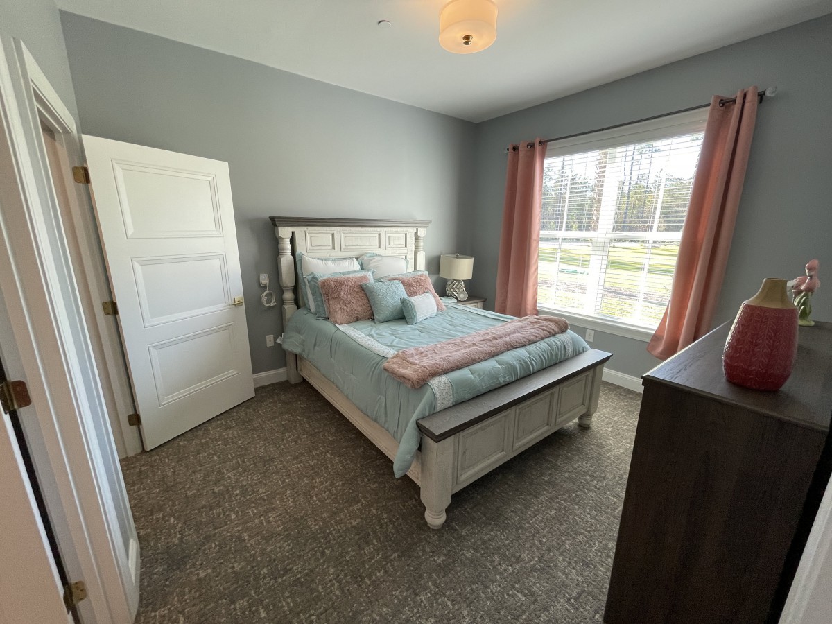 Cozy bedroom with a large window and elegant furnishings.
