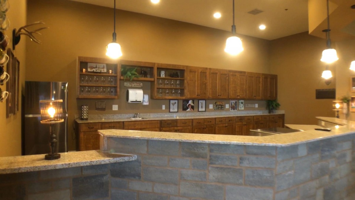 A modern kitchen interior with wooden cabinets and pendant lighting.