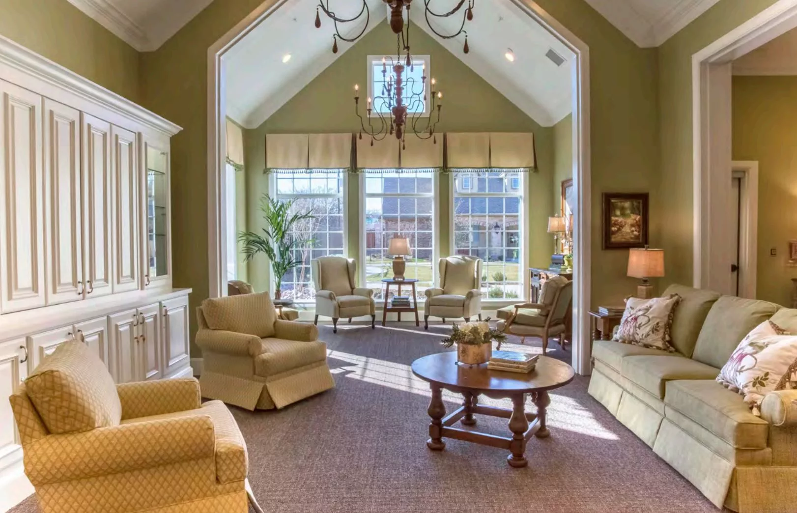 A spacious and elegantly furnished living room with large windows allowing in natural light.