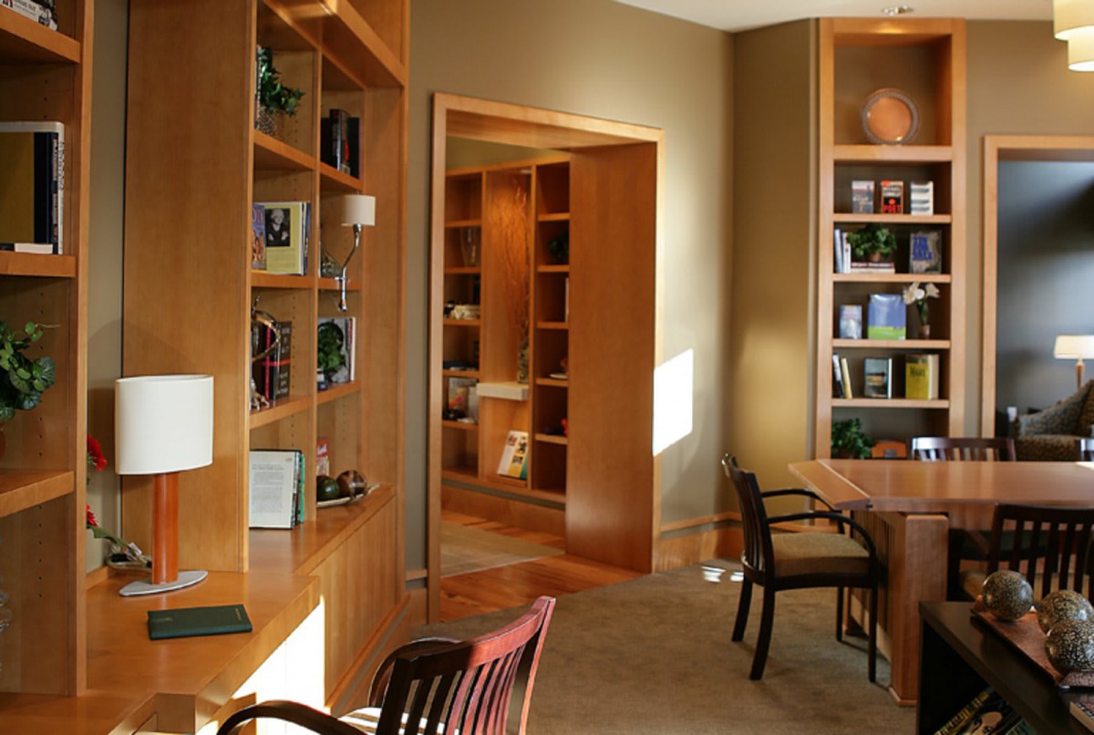 A cozy home office with wooden bookshelves and a desk.