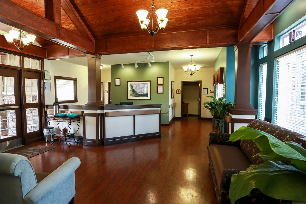 A modern office lobby with wooden floors and elegant lighting.