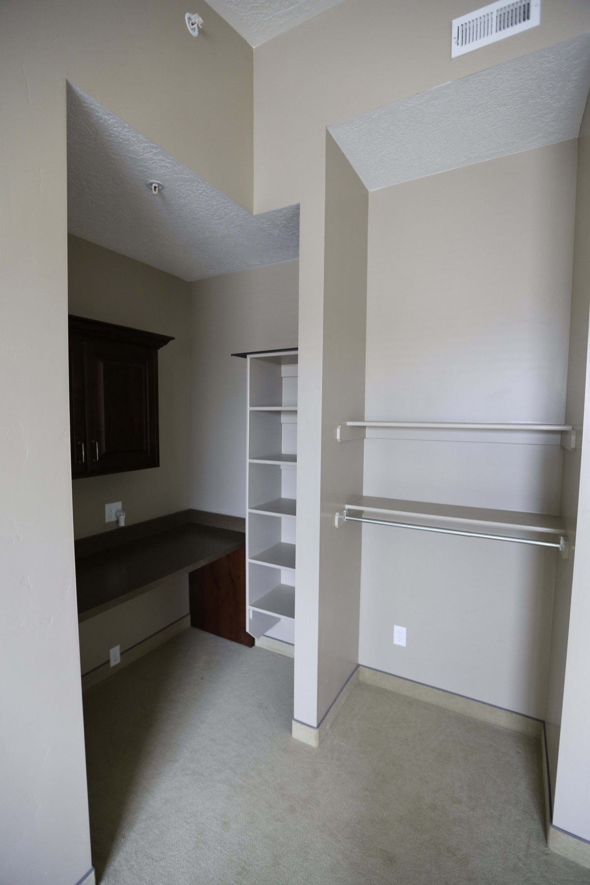 A minimalist closet interior featuring open shelves and hanging rods for storage.