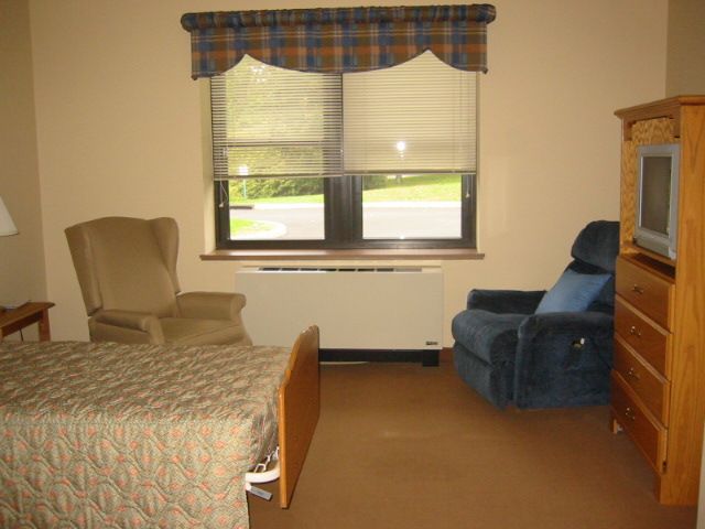 A cozy bedroom with two armchairs and a window.