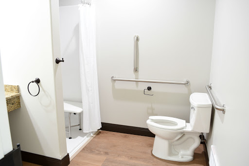 A clean and accessible bathroom featuring a toilet and shower area.