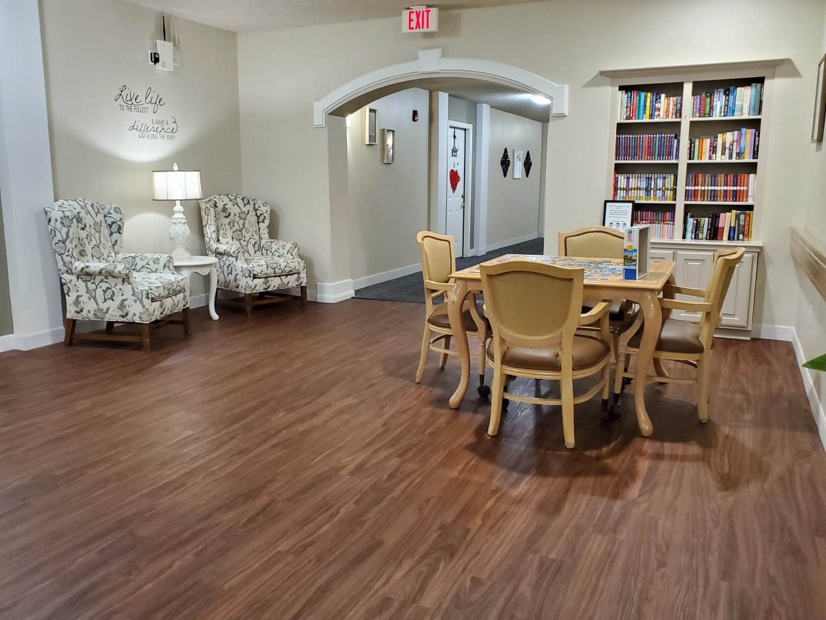 Comfortable reading and seating area with bookshelves and wooden flooring.
