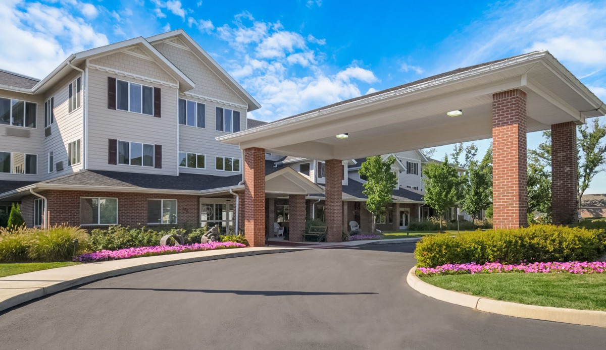 Entrance to a well-maintained retirement home with a landscaped driveway.