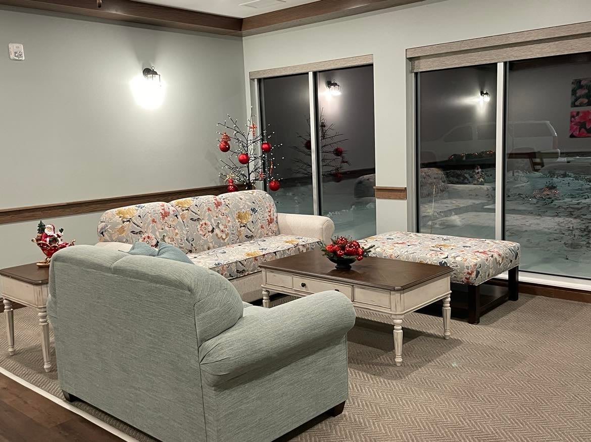 A cozy living room with a floral-patterned sofa and sliding glass doors.
