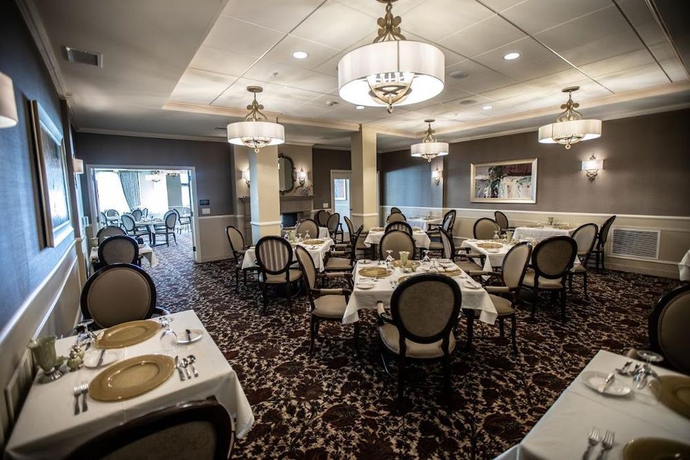 A sophisticated dining room with elegant chandeliers and neatly arranged tables.