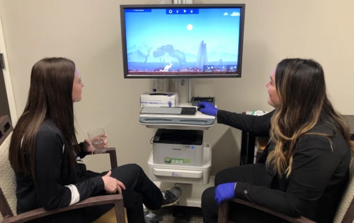 Two women in a medical setting discussing visuals on a monitor.