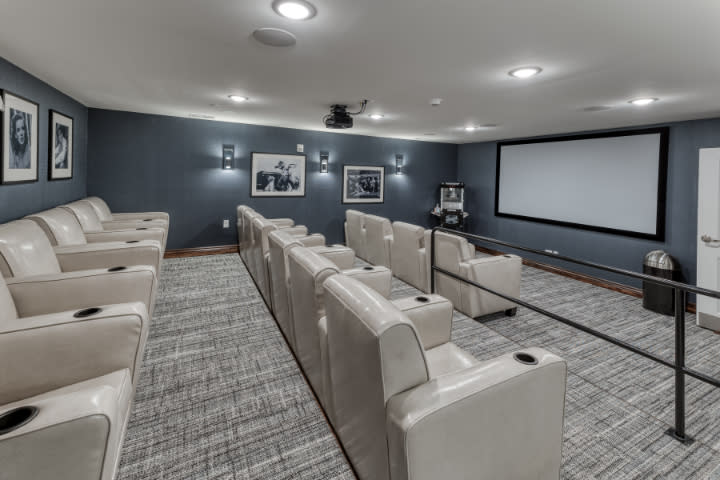 A luxurious home theater setup with plush reclining seats and a large projector screen.