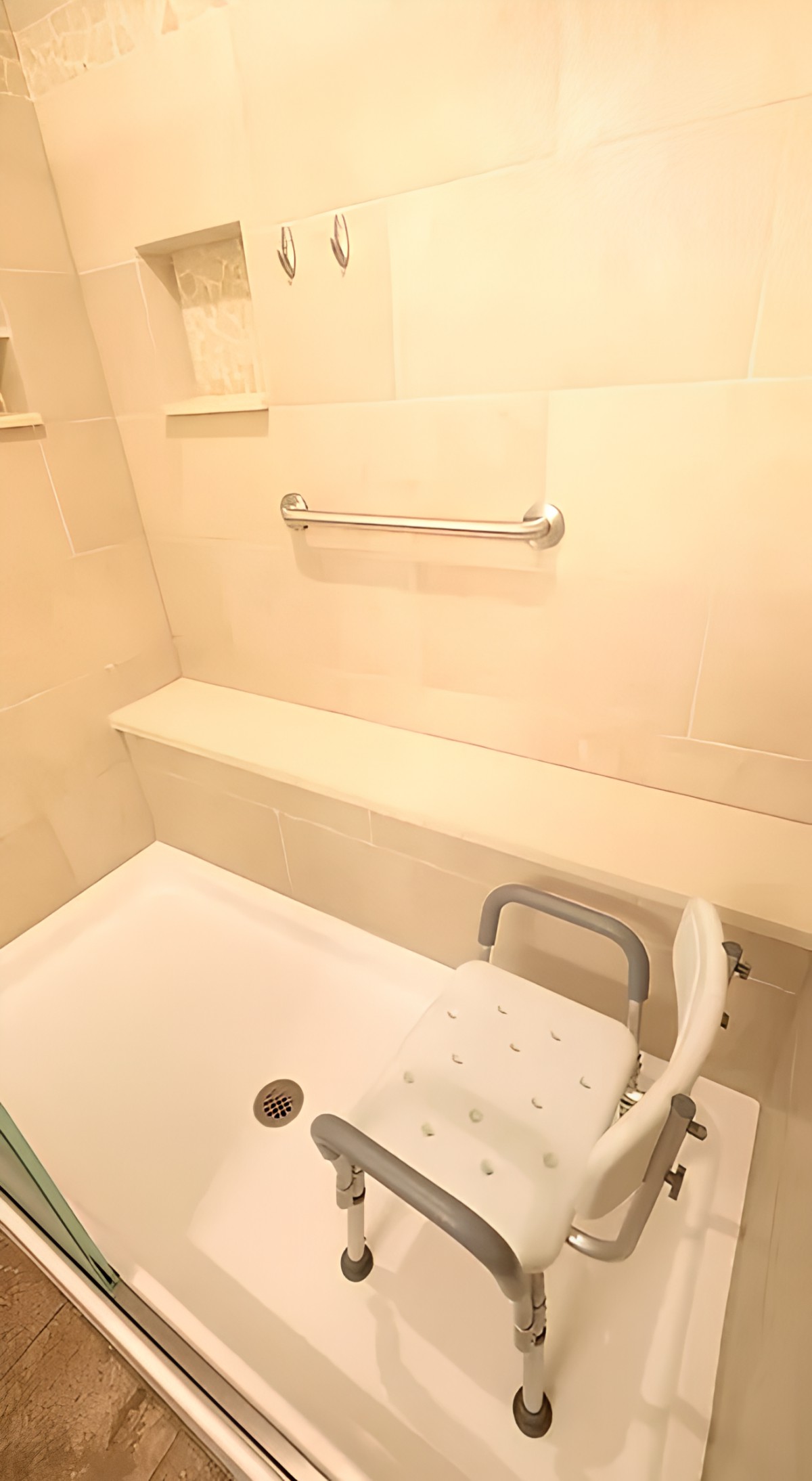 Accessible bathroom with a shower seat and grab bar.