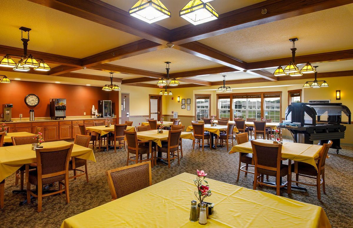 A cozy dining area with neatly arranged tables and warm lighting.