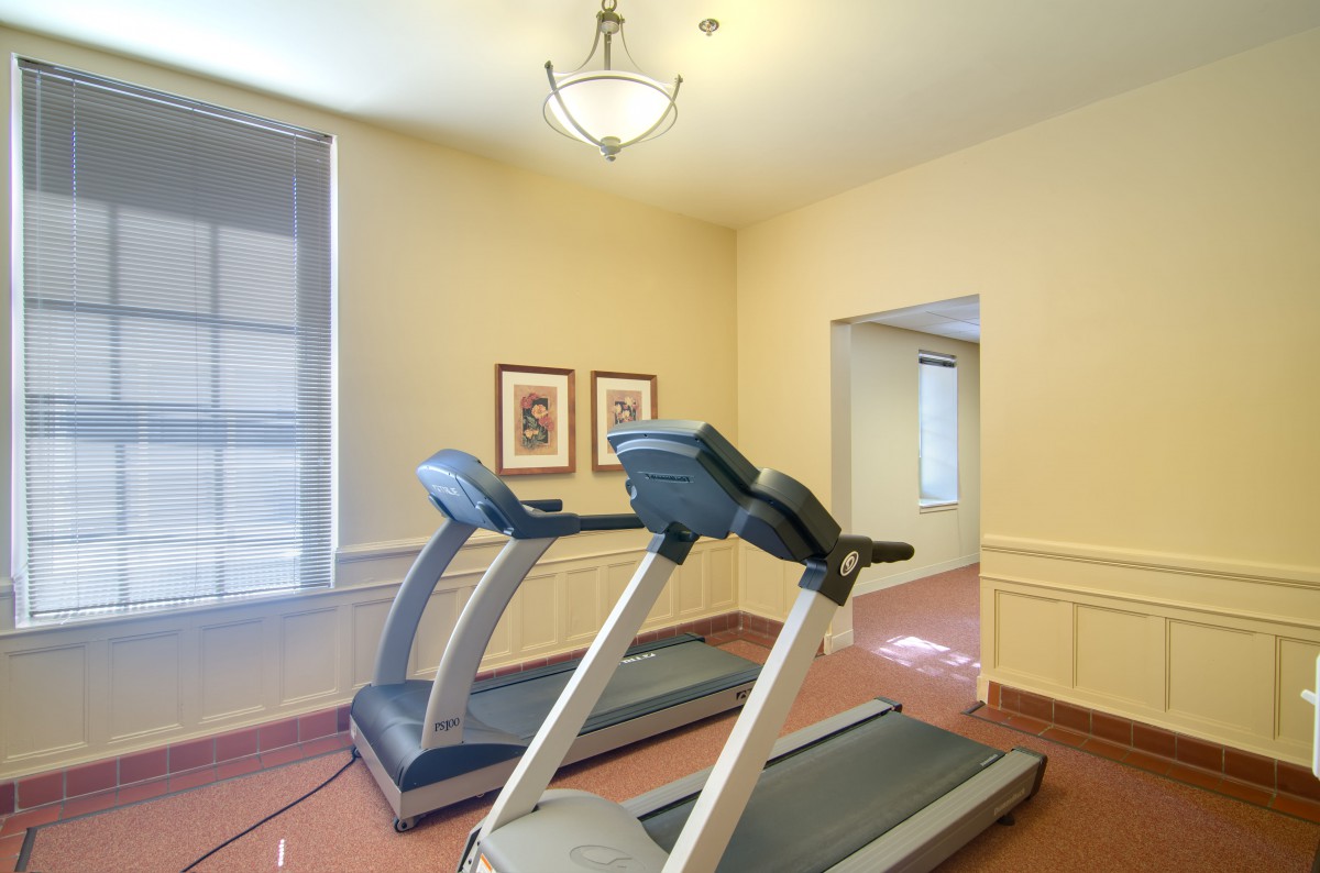 A small gym with two treadmills placed side by side.