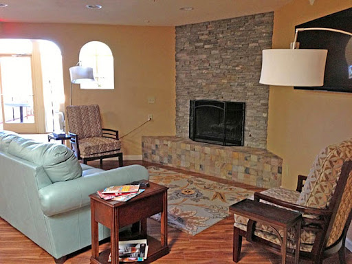 A cozy living room featuring a stone fireplace and comfortable seating.