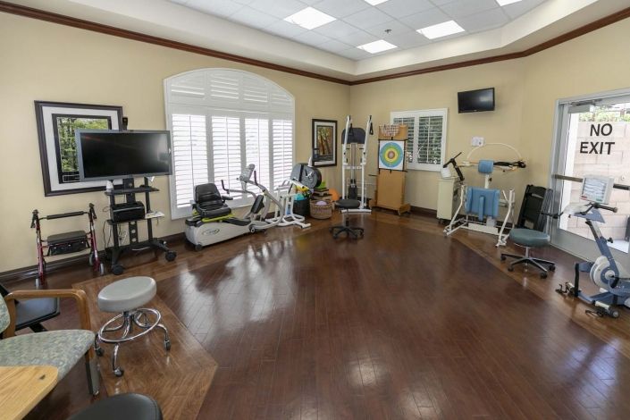 A well-equipped physical therapy and rehabilitation room with various exercise machines.