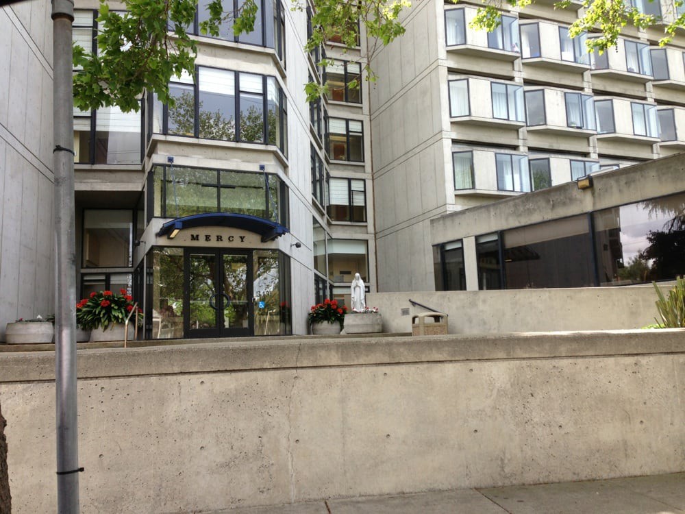 Modern building entrance with large windows and concrete facade.
