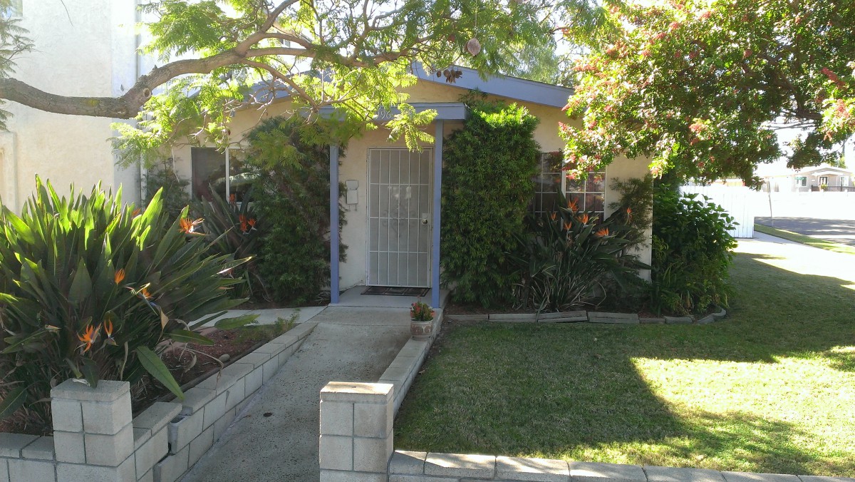 A cozy house with a lush front yard and a pathway leading to the door.