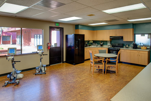 A well-lit kitchen and dining area featuring a table and chairs, refrigerator, and cabinets.