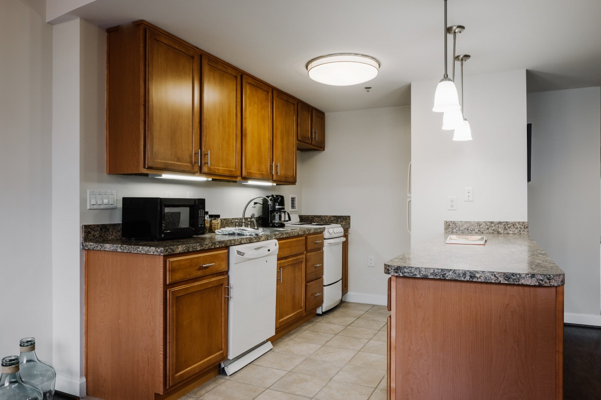 A modern kitchen with wooden cabinets, a microwave, and a dishwasher.