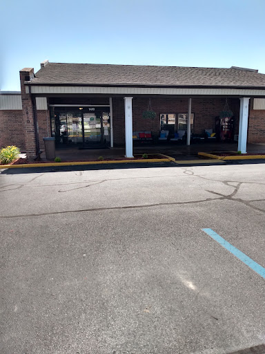 A view of a commercial building entrance with a parking lot in front.