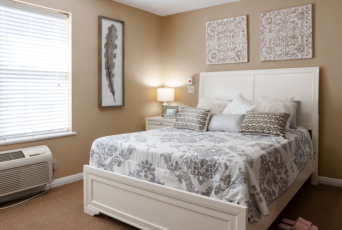 A cozy bedroom with tasteful decor, featuring a large bed, patterned bedding, and decorative artwork on the walls.