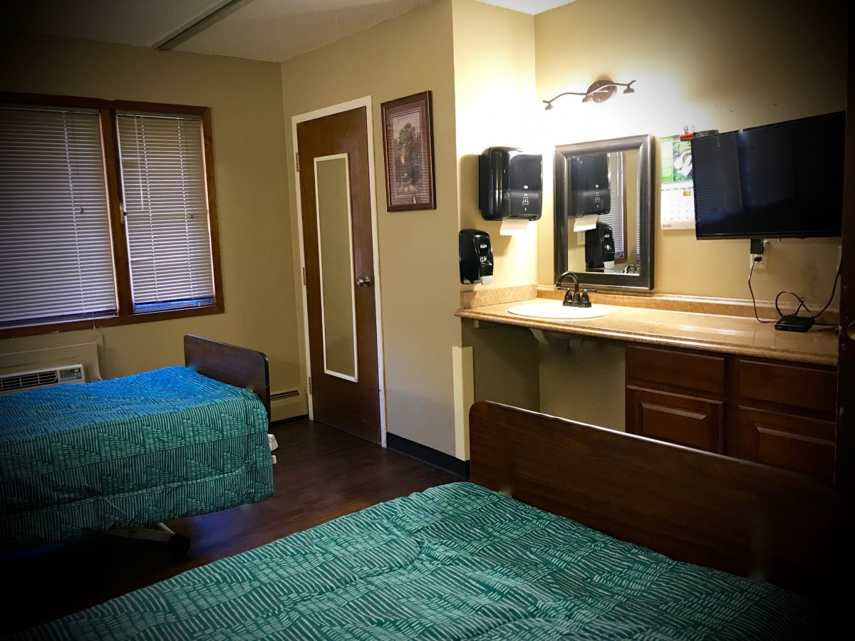 A cozy bedroom with twin beds and a vanity area.