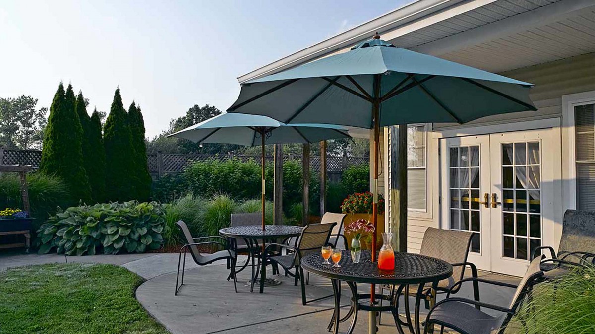A cozy outdoor patio with tables and umbrellas, perfect for a summer day.