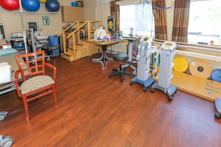 A therapy room equipped with various medical and exercise equipment for rehabilitation.