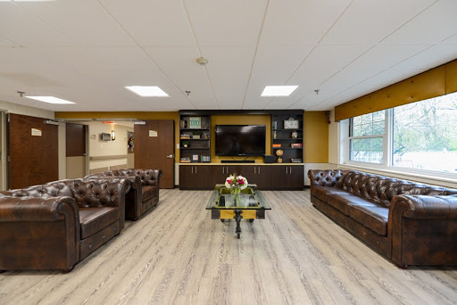 A cozy and modern lounge area designed for relaxation and comfort, featuring stylish furniture and a television.