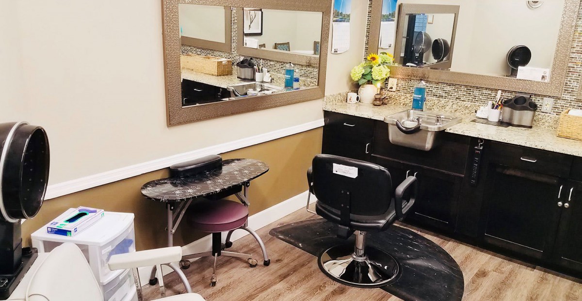 A clean and well-organized hair salon station with styling chairs and a mirror.