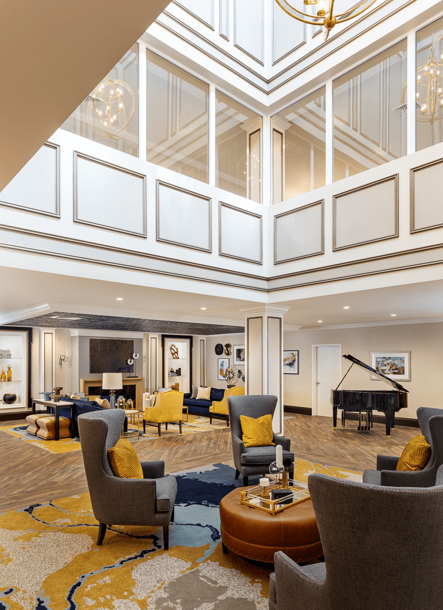 A modern lobby interior with comfortable seating and a grand piano.