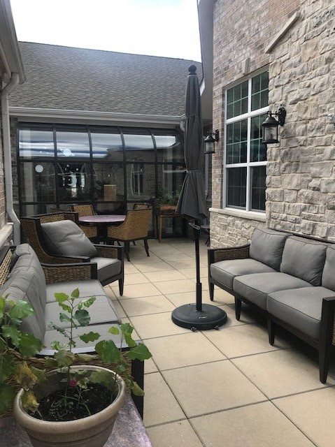 A cozy outdoor patio area with comfortable seating and a large umbrella.