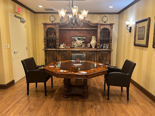 A cozy conference room featuring an octagonal wooden table and elegant seating, complemented by a chandelier.