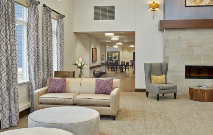 A modern living room with neutral tones, featuring a comfortable sofa, armchair, and stylish decor.
