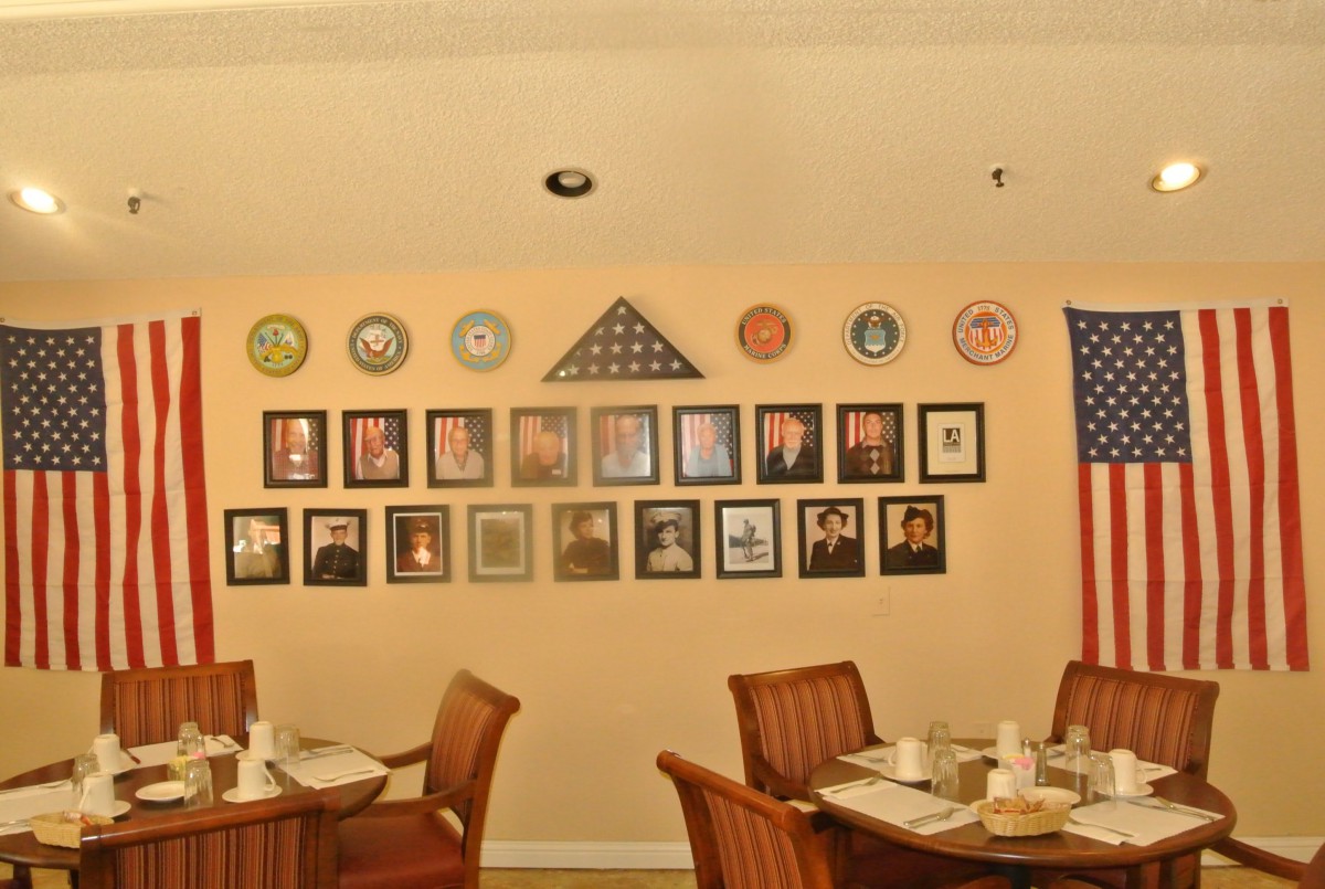 A dining area adorned with military memorabilia, including framed photos and an American flag.