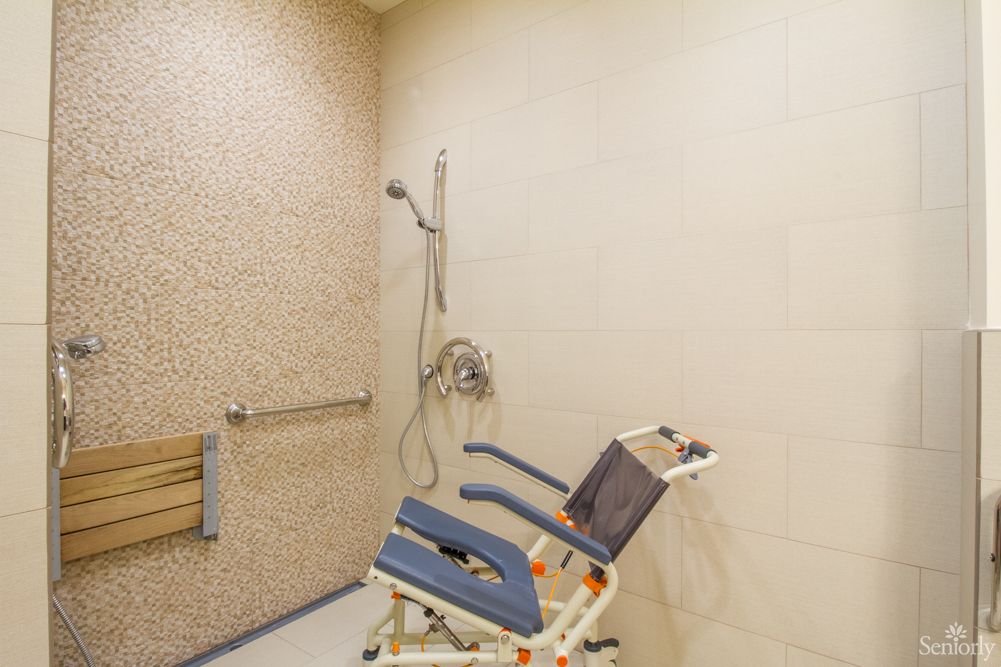 An accessible shower room equipped with a specialized wheelchair for ease of use.