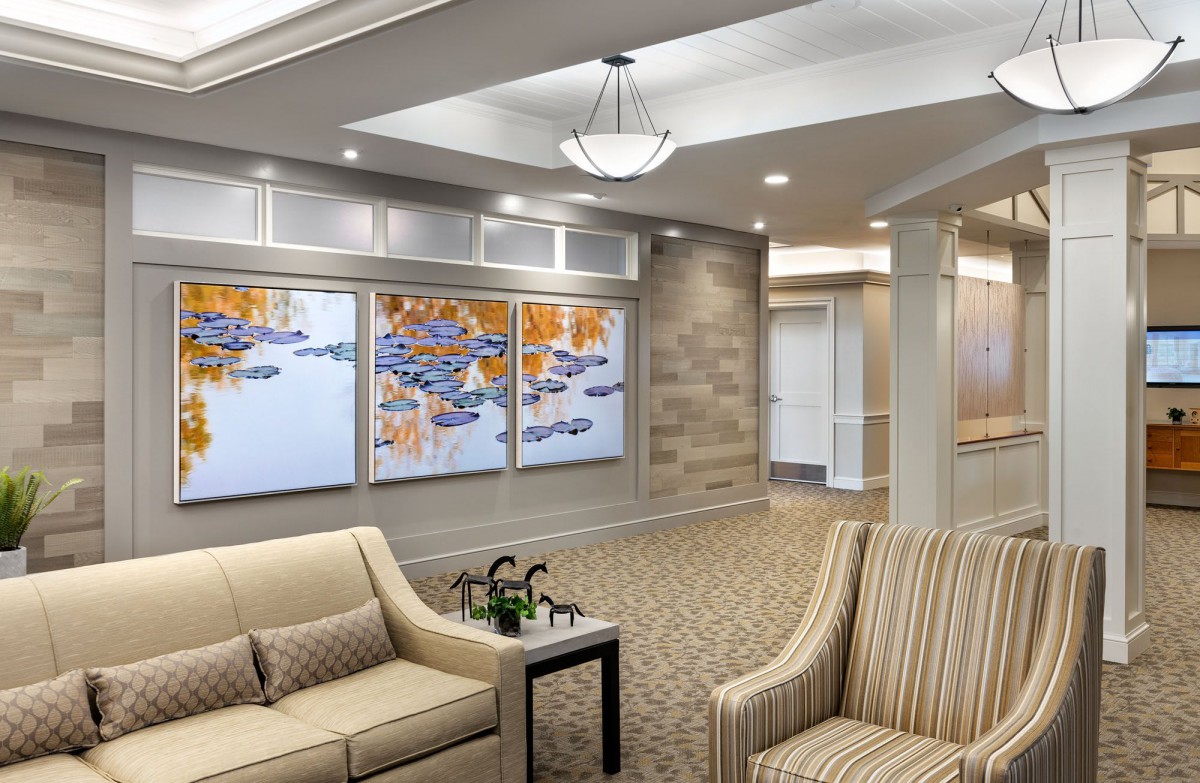 A modern lobby with comfortable seating and colorful artwork on the wall.