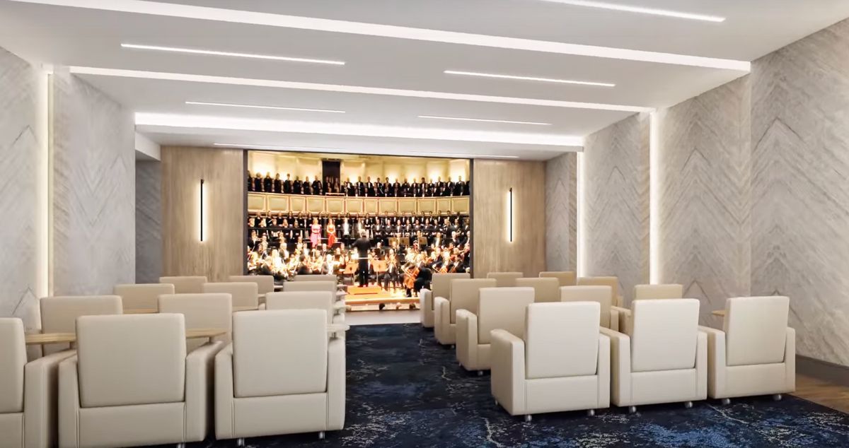 A modern theater with comfortable seating facing a stage.