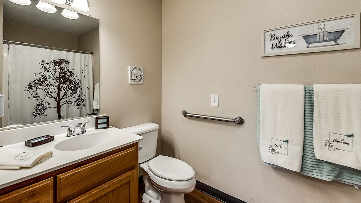 A clean bathroom with a toilet, sink, and towel rack.