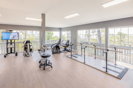 A bright and spacious gym filled with exercise equipment, offering a great environment for workouts.