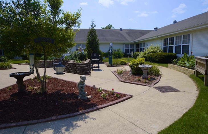 A beautifully landscaped garden with winding pathways and surrounding buildings.