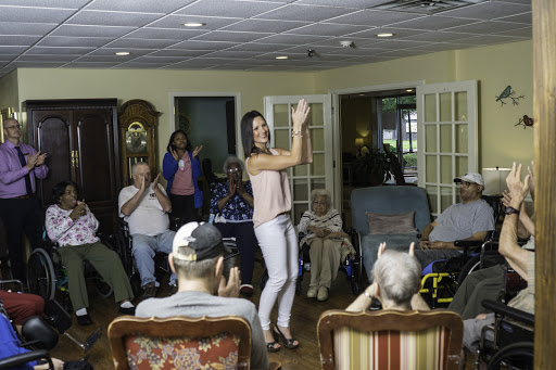 A lively performance is taking place, with an engaged audience of seniors enjoying the entertainment.